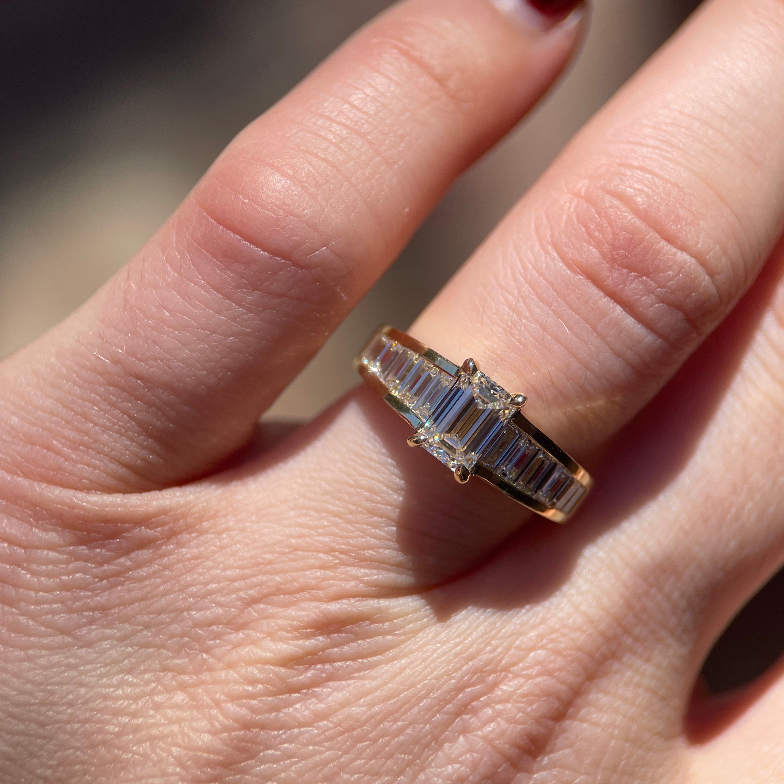 Hand with a diamond engagement ring.