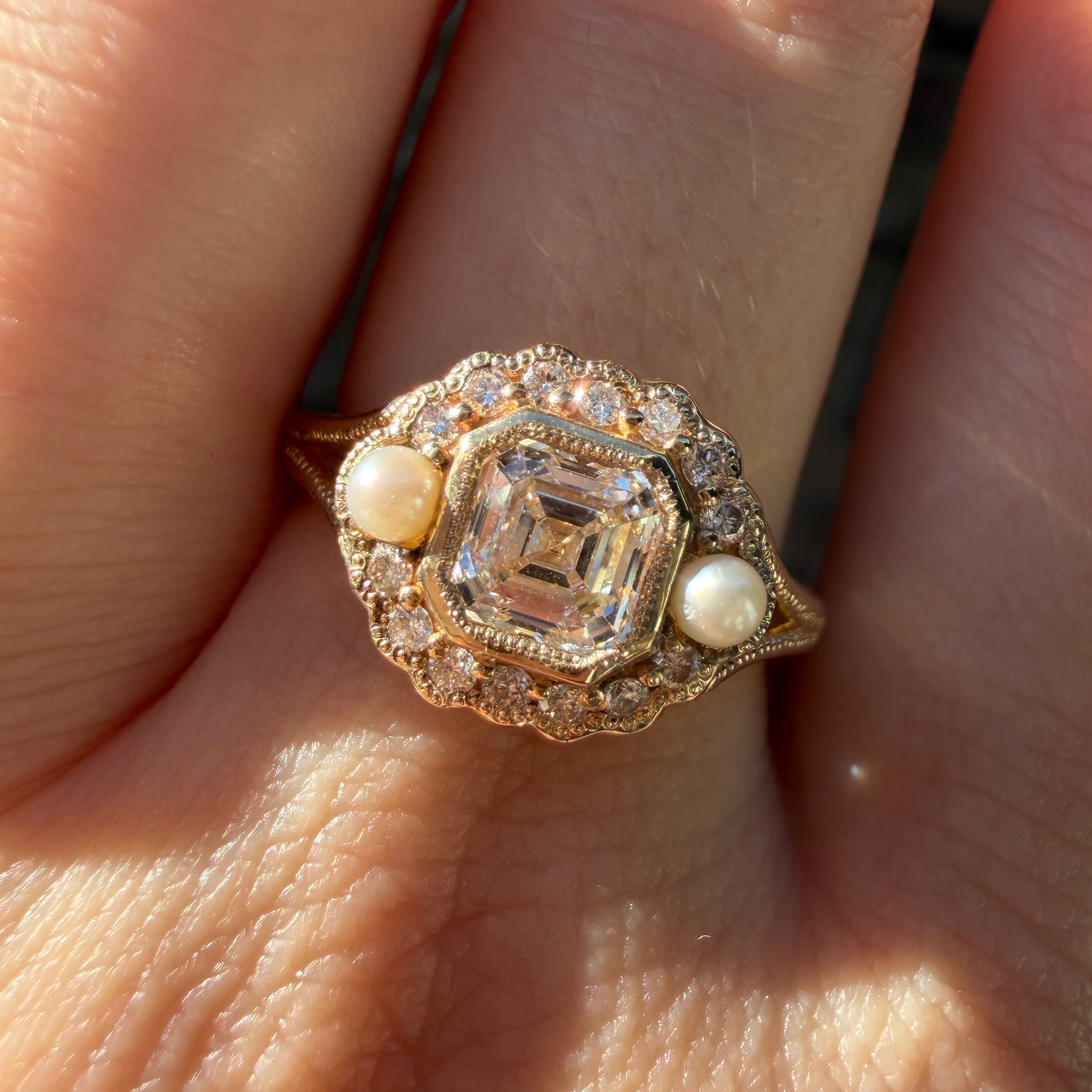 Gold ring with diamonds and pearls on a finger