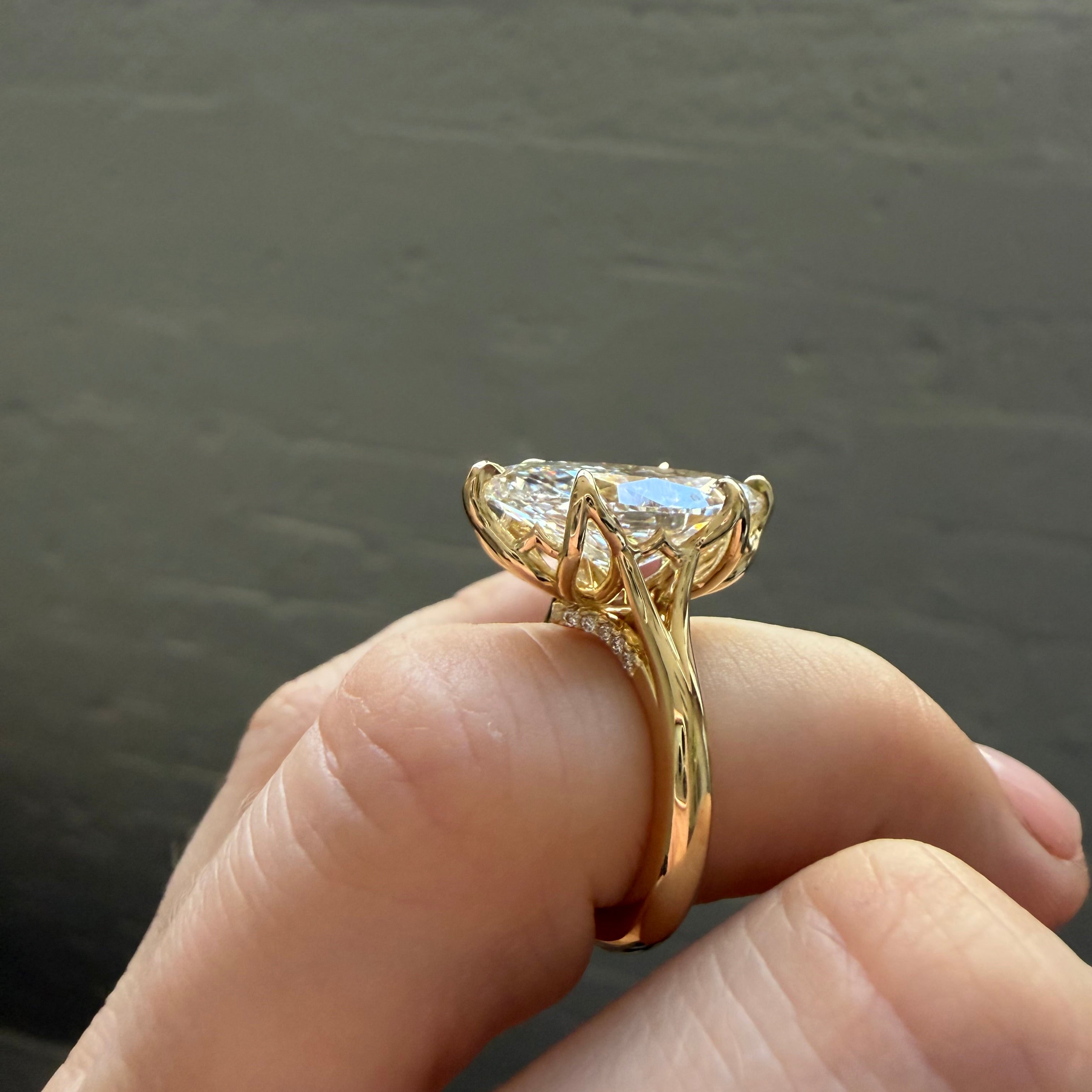 Gold ring with a diamond on a hand against a neutral background
