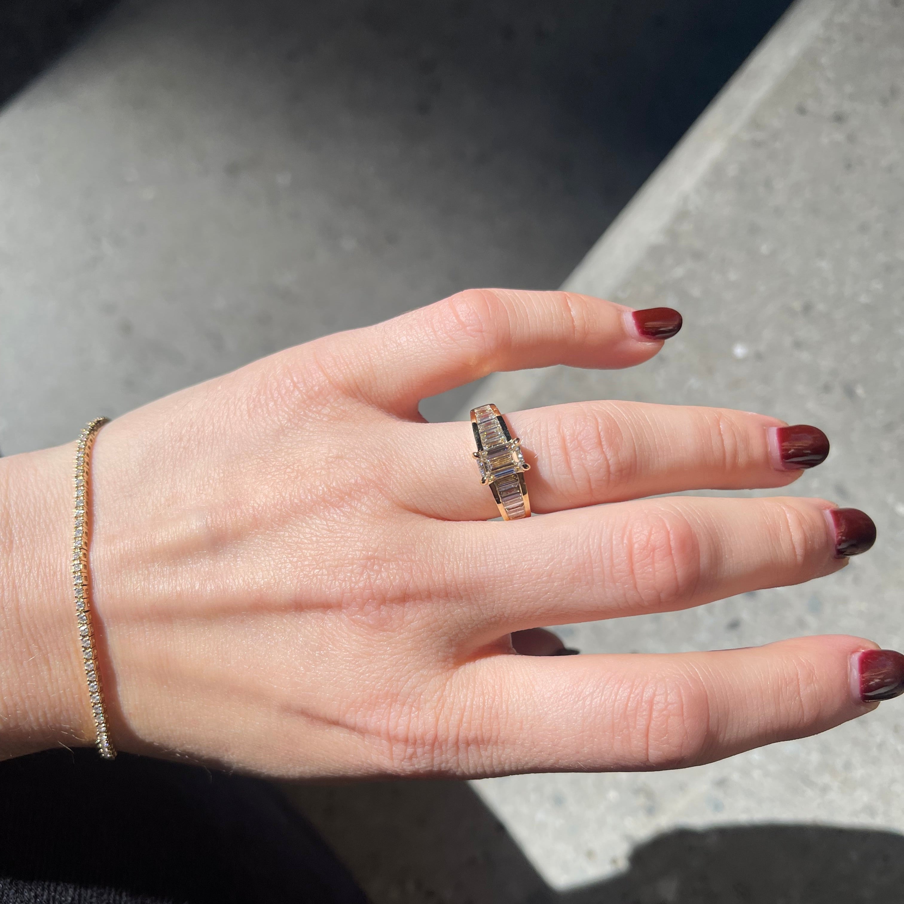 Hand with diamond bracelet and diamond engagement ring.