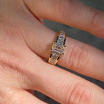 Hand with diamond engagement ring.